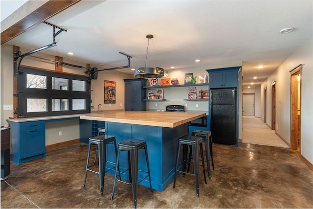 771 Zumbro Oaks Ln NW, Oronoco, MN 55960 - kitchen with open shelves, freestanding refrigerator, butcher block counters, finished concrete flooring, and blue cabinetry