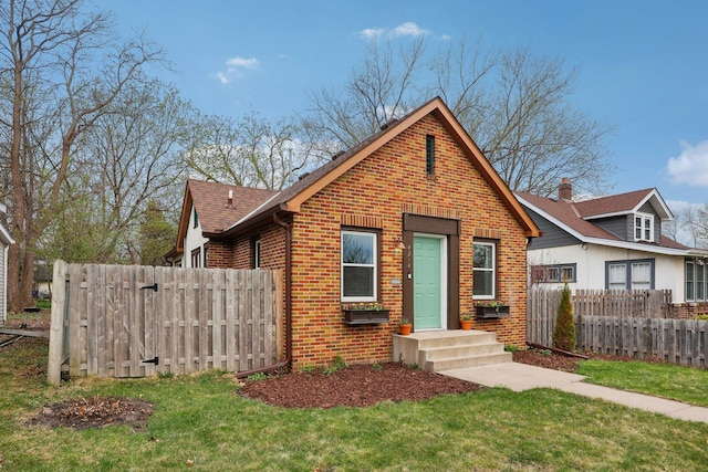 bungalow-style home with brick siding, fence, roof with shingles, and a front lawn