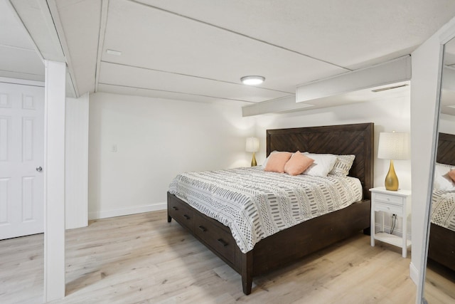 bedroom with baseboards and wood finished floors