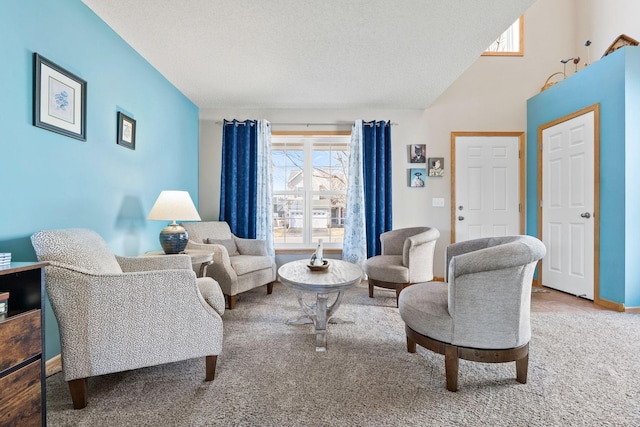 carpeted living area with a textured ceiling and baseboards