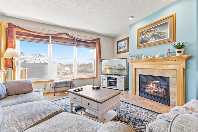 living area featuring a textured ceiling and a tiled fireplace