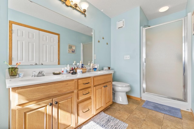 bathroom with a sink, a shower stall, toilet, and double vanity