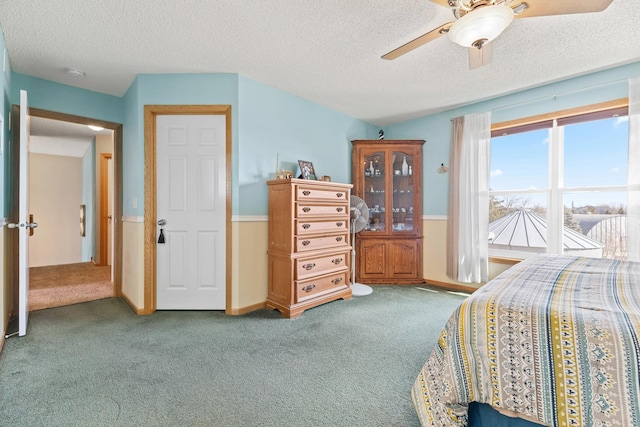 bedroom featuring ceiling fan, a textured ceiling, and carpet flooring