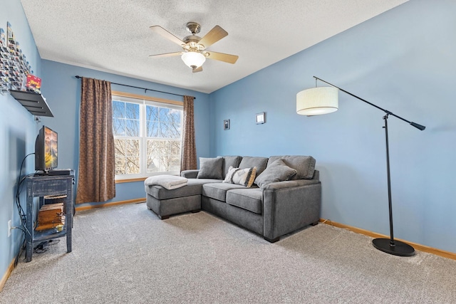 carpeted living area featuring a textured ceiling, a ceiling fan, and baseboards