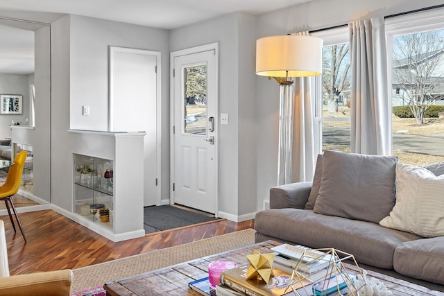 living area with baseboards and wood finished floors