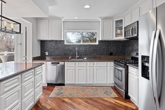 kitchen featuring dark wood-style flooring, a sink, white cabinets, and stainless steel appliances