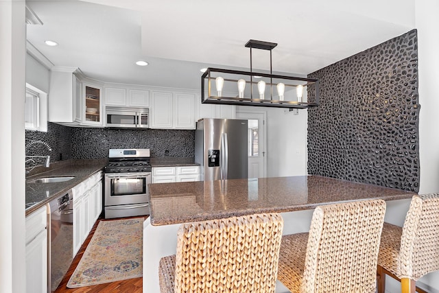 kitchen with stainless steel appliances, white cabinets, and backsplash