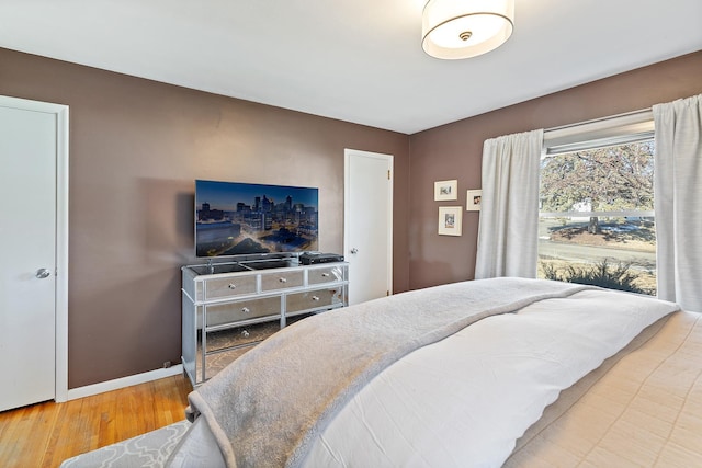 bedroom with wood finished floors and baseboards