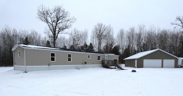 view of front of house with an outbuilding, a garage, and a deck