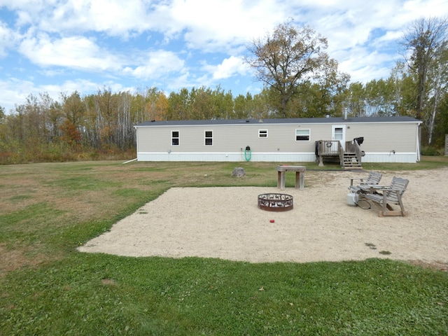 view of property's community featuring a yard, a fire pit, a patio, and a deck