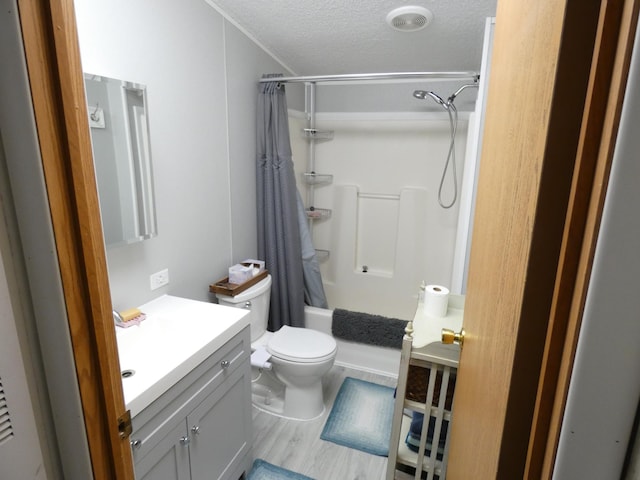 full bathroom with toilet, a textured ceiling, hardwood / wood-style flooring, vanity, and shower / bath combination with curtain