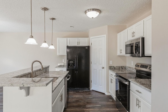 kitchen with pendant lighting, stainless steel appliances, white cabinets, and a center island with sink