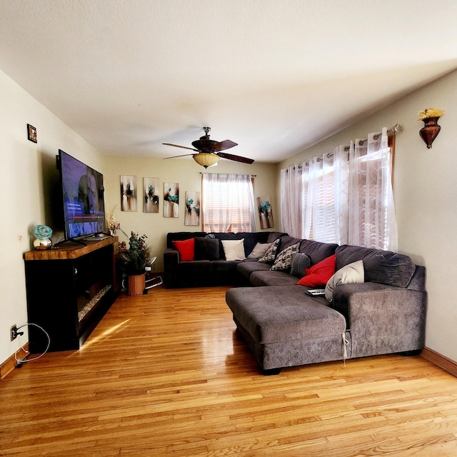 living room with ceiling fan, lofted ceiling, and light hardwood / wood-style floors