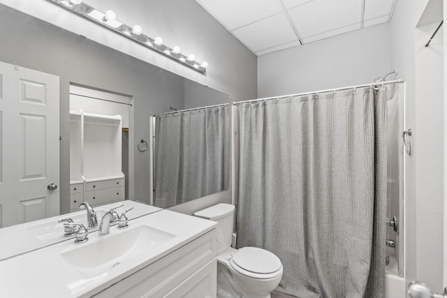 full bathroom with shower / bathtub combination with curtain, vanity, a paneled ceiling, and toilet