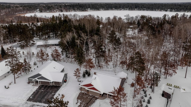 snowy aerial view featuring a forest view