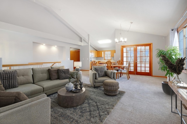 living room with light carpet, a notable chandelier, high vaulted ceiling, and a healthy amount of sunlight