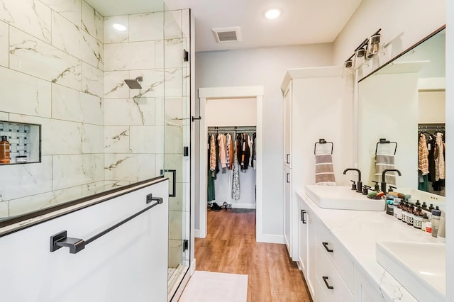 bathroom with wood-type flooring, an enclosed shower, and vanity