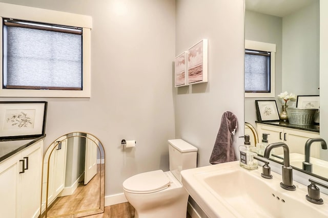 bathroom with hardwood / wood-style flooring, sink, and toilet