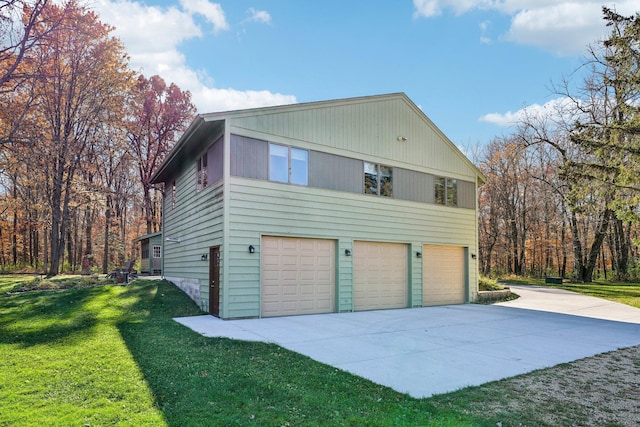 view of property exterior featuring driveway, a yard, and an attached garage