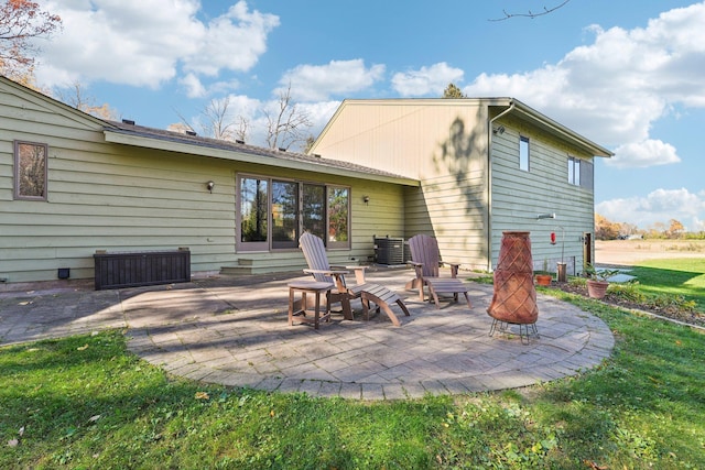 rear view of property featuring a patio area and a lawn