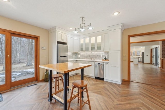 kitchen with white cabinetry, visible vents, stainless steel appliances, and a sink