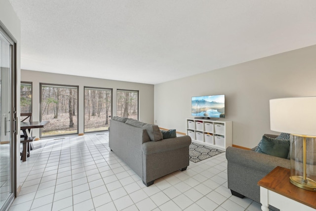 living area with baseboards and light tile patterned floors