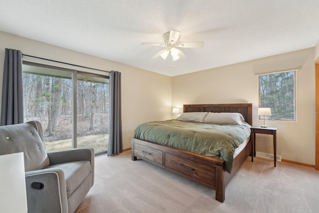 bedroom featuring a ceiling fan, light carpet, a textured ceiling, and baseboards