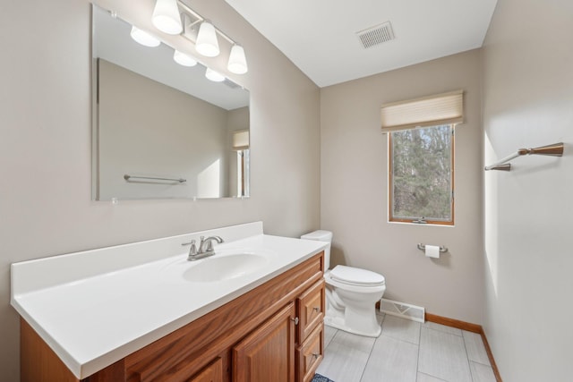 bathroom featuring baseboards, visible vents, vanity, and toilet