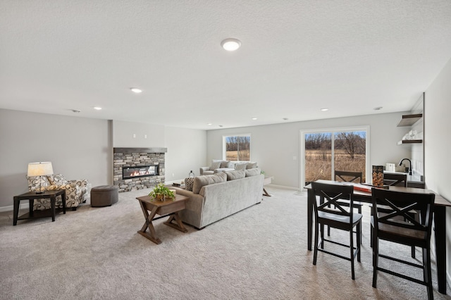 carpeted living room with a fireplace and a textured ceiling