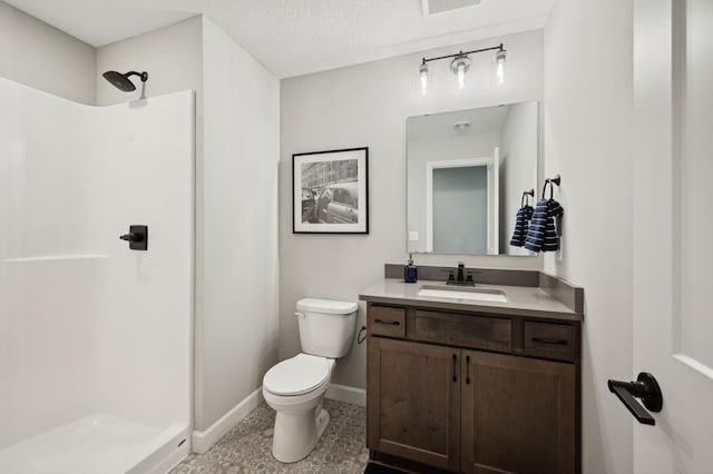 bathroom with vanity, toilet, and a shower