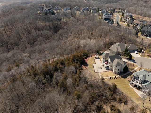 drone / aerial view featuring a residential view and a wooded view