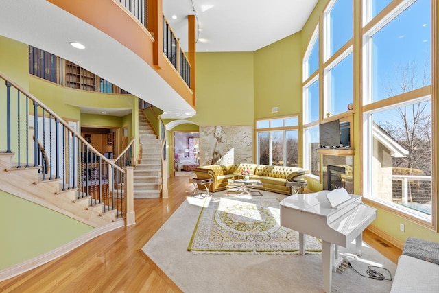 living room with a high ceiling, wood finished floors, and stairs