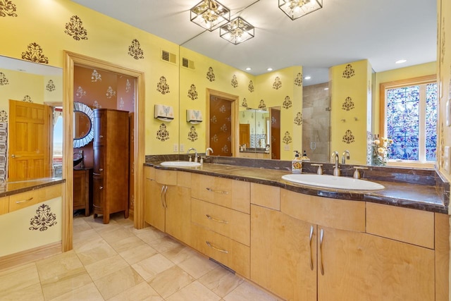 bathroom featuring double vanity, a sink, visible vents, and a stall shower