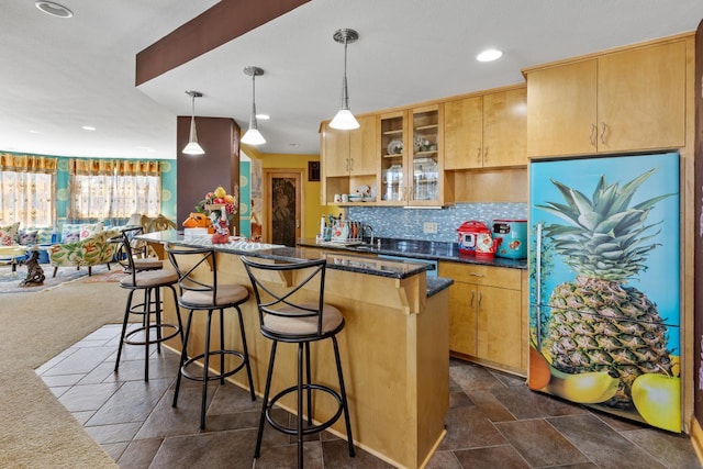 kitchen with recessed lighting, a breakfast bar, a kitchen island, decorative backsplash, and hanging light fixtures