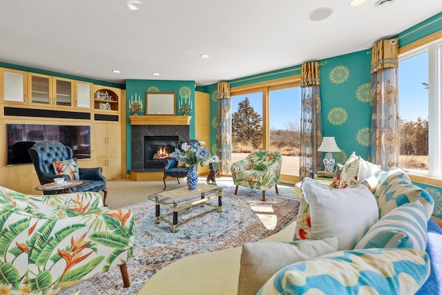living room with plenty of natural light, a glass covered fireplace, carpet, and recessed lighting