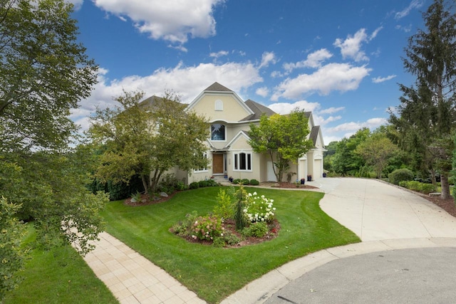 view of front of property featuring an attached garage, driveway, a front yard, and stucco siding