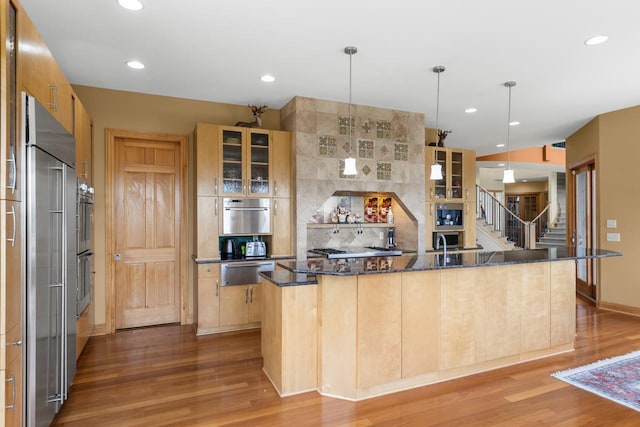 19115 Vogel Farm Trl, Eden Prairie, MN 55347 - kitchen with a warming drawer, stainless steel appliances, wood finished floors, a large island with sink, and recessed lighting