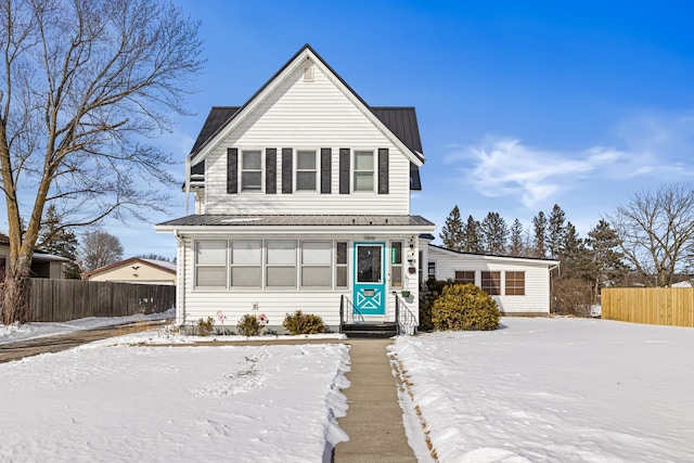 traditional-style home with entry steps, fence, and metal roof