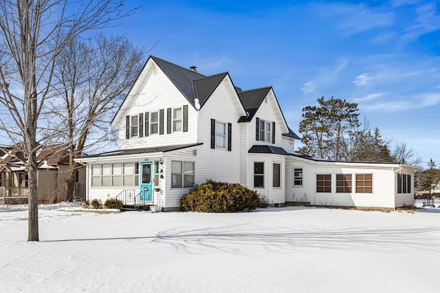 view of front of property with metal roof, a standing seam roof, and a chimney