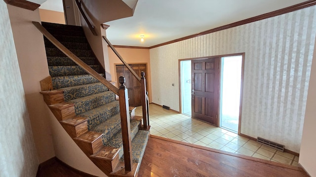 entrance foyer with light wood-type flooring and crown molding