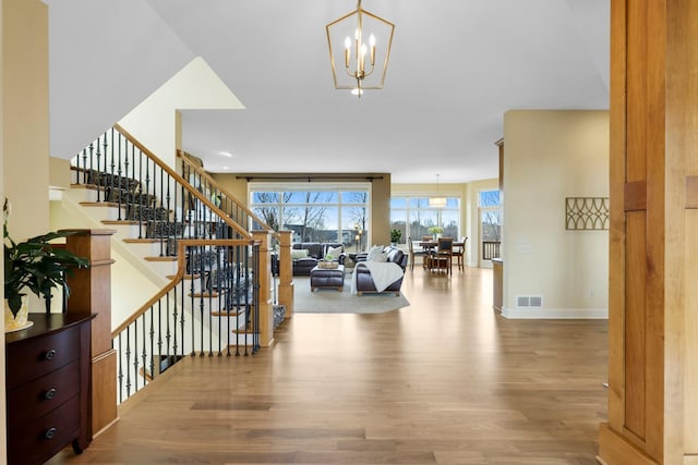 entryway featuring stairs, visible vents, a healthy amount of sunlight, and wood finished floors