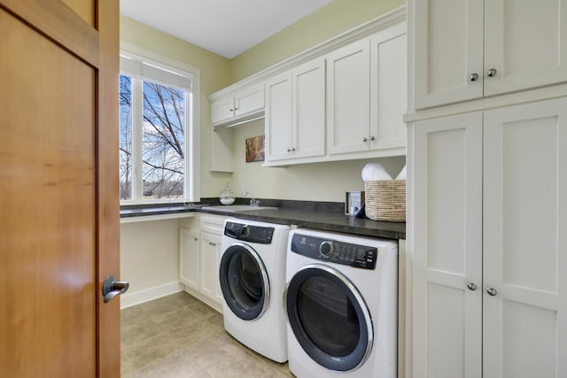 laundry room featuring baseboards, a sink, cabinet space, independent washer and dryer, and light tile patterned floors