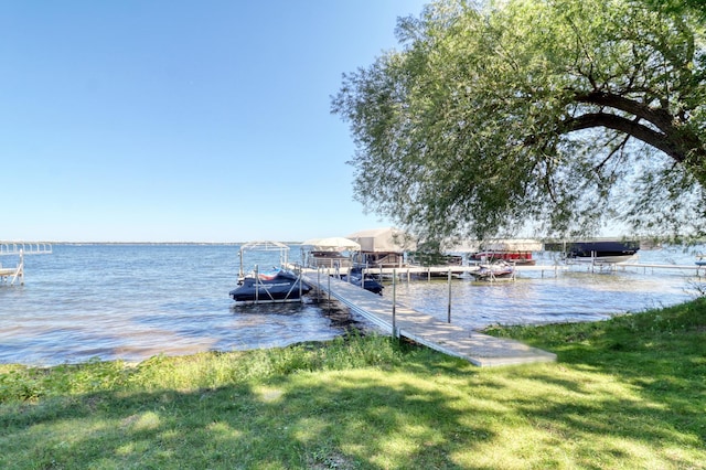 view of dock with a water view and a yard