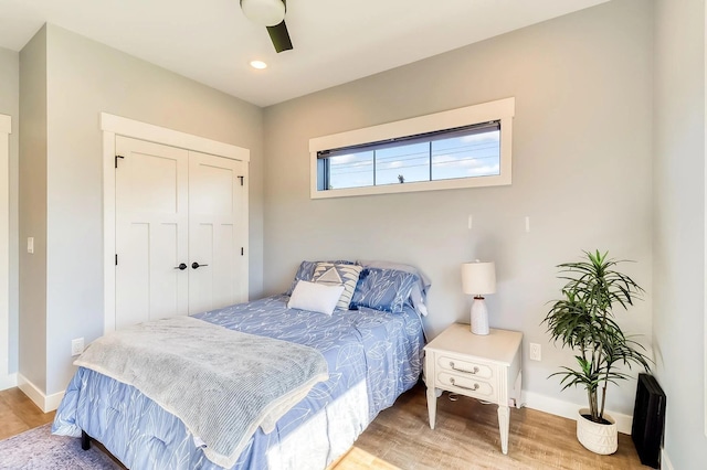 bedroom with wood-type flooring, ceiling fan, and a closet