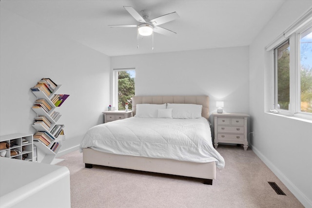 carpeted bedroom featuring ceiling fan and multiple windows