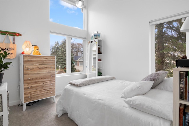 carpeted bedroom featuring a high ceiling