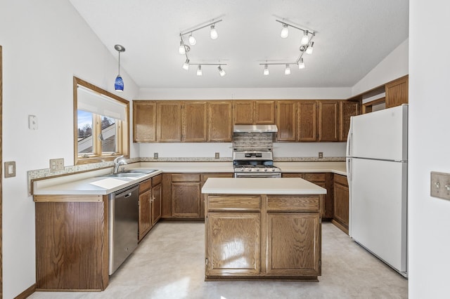 kitchen featuring under cabinet range hood, a kitchen island, a sink, light countertops, and appliances with stainless steel finishes