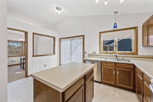 kitchen with a sink, vaulted ceiling, light countertops, stainless steel dishwasher, and decorative light fixtures