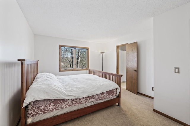 bedroom with light colored carpet, a textured ceiling, and baseboards