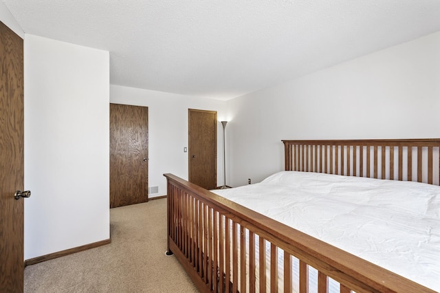 carpeted bedroom with visible vents and baseboards